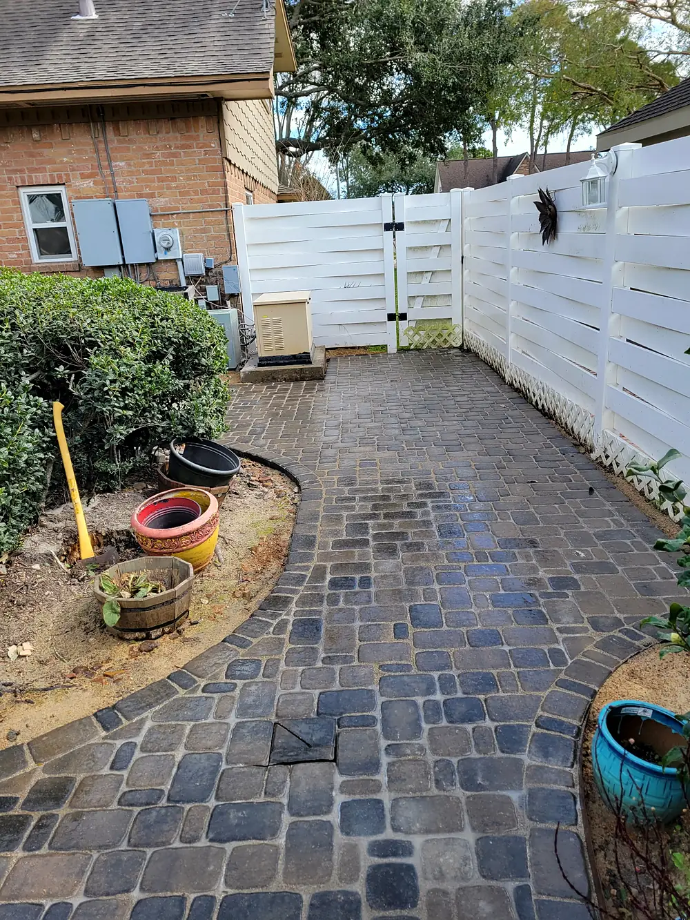 Cobblestone paver side yard with a curved border