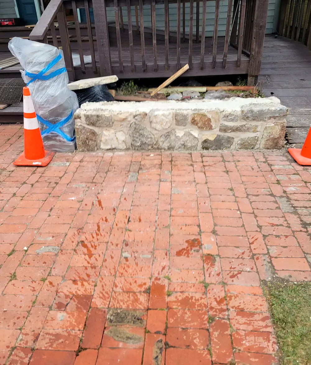 A low natural stone wall going in along a wooden porch