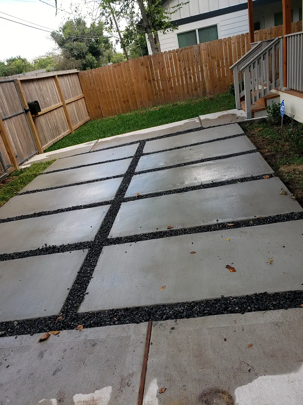 Concrete pads and black gravel leading to the back steps